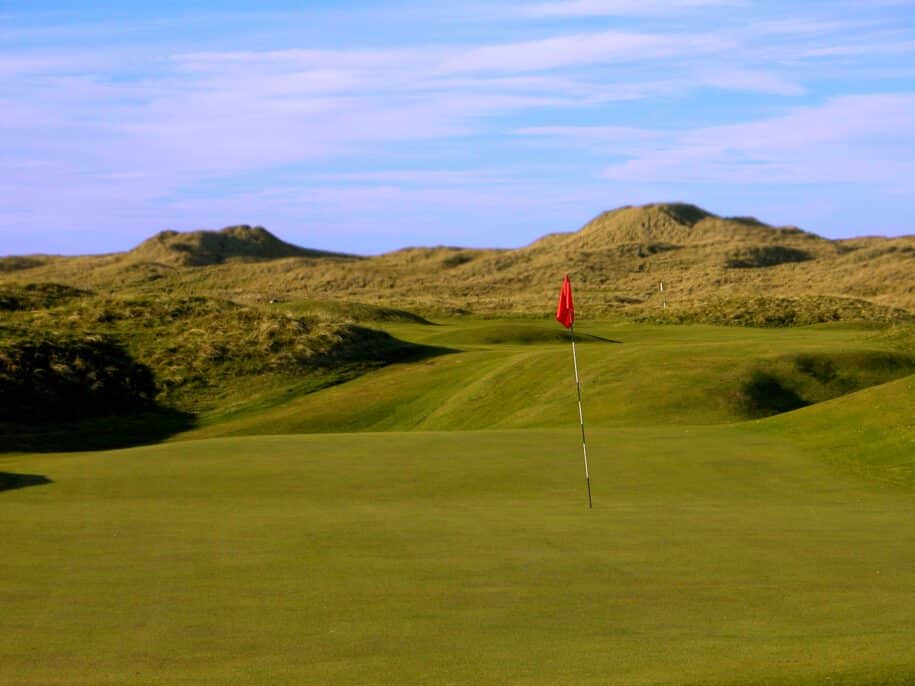 image of a golf course near hills