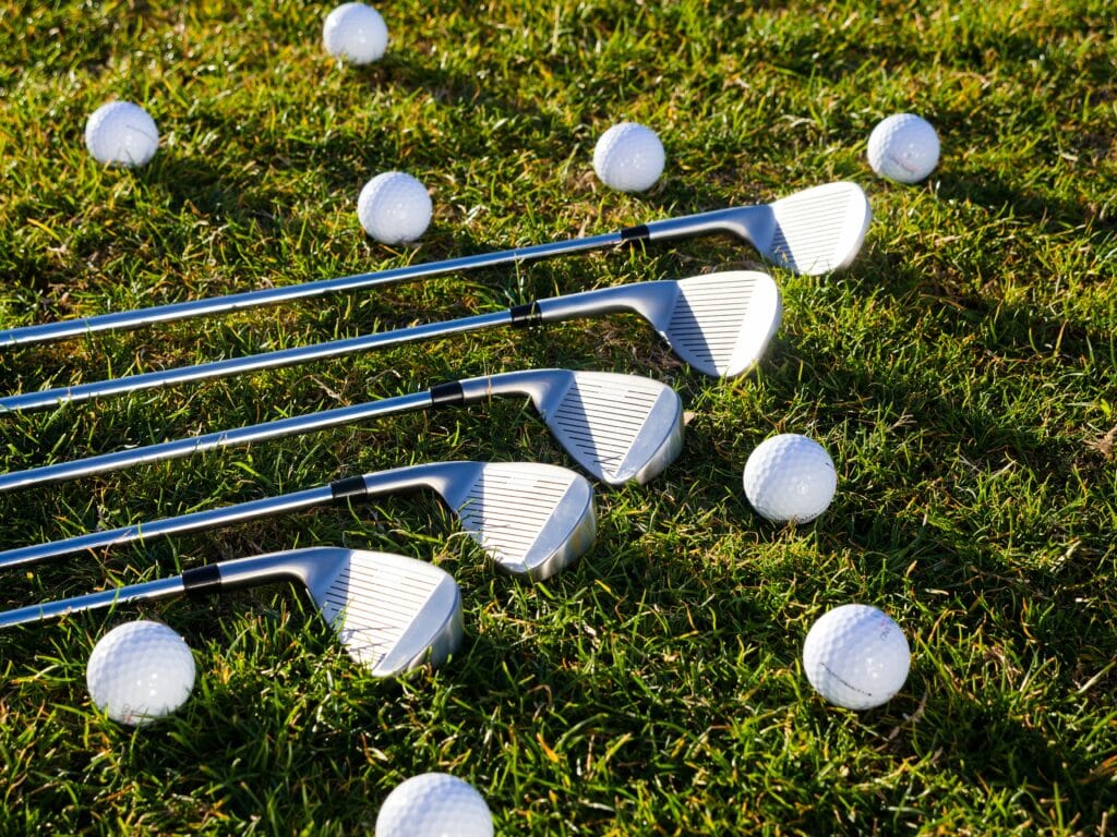 golf balls and golf club on the grass.
